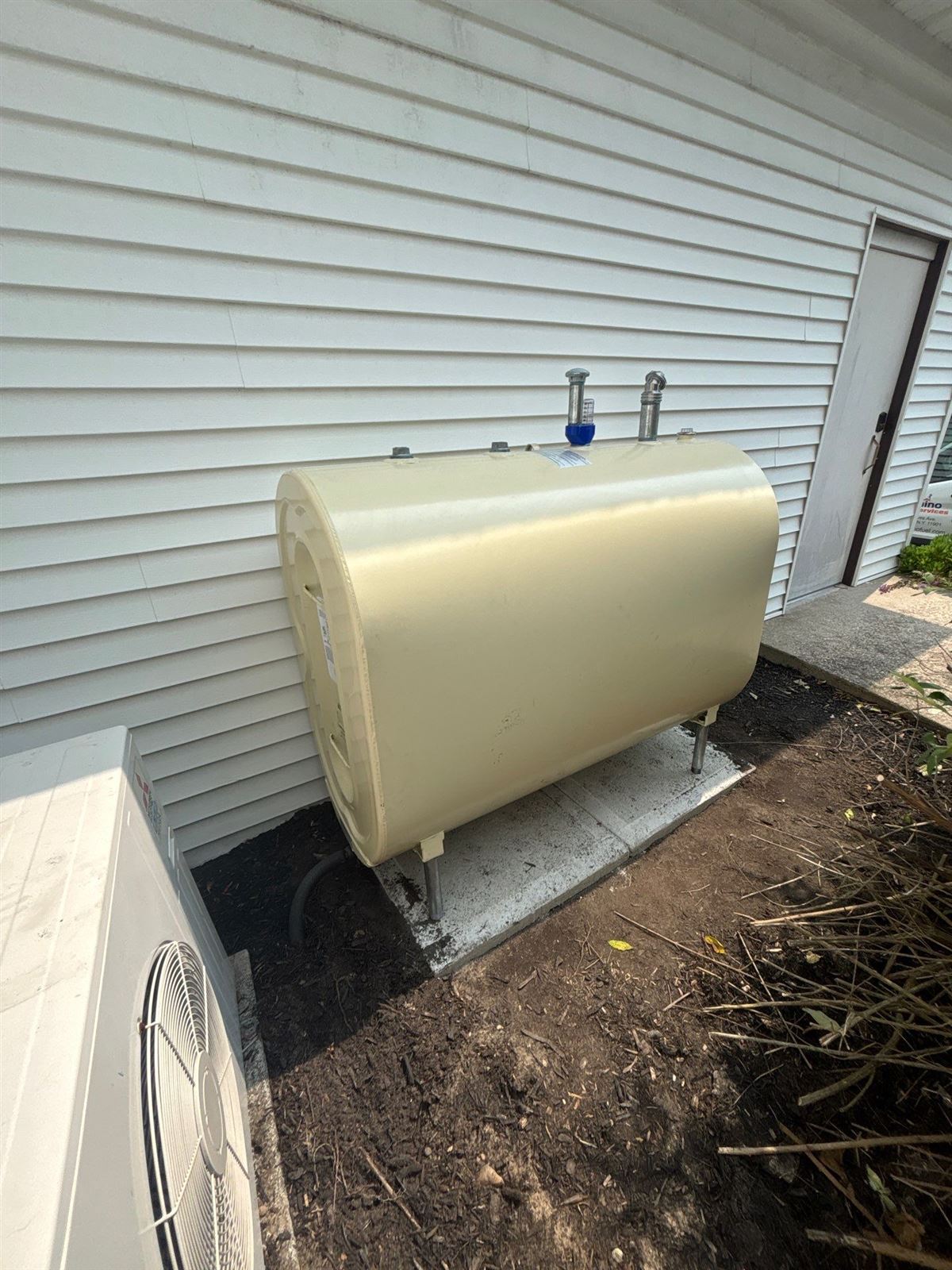 New Granby oil tank installed on a pad next to a home
